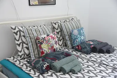 a bed with several pillows on top of it at Apartment Tesla Space in Belgrade