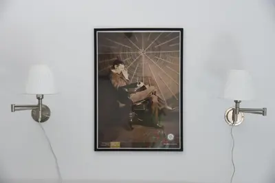 a framed painting of a woman sitting in a chair at Apartment Tesla Space in Belgrade