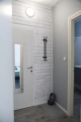 a hallway with a white wall with a mirror at Apartment Tesla Space in Belgrade