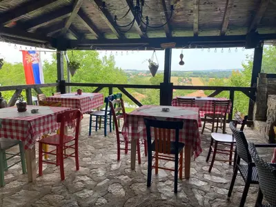 a group of tables and chairs in a restaurant at Bas u inat babarogama in Koraćica