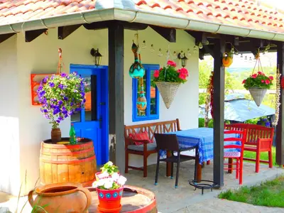 a patio with a table and chairs and a house at Bas u inat babarogama in Koraćica
