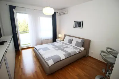 a bedroom with a bed and a large window at Apartment Delta City Tata New Belgrade in Belgrade