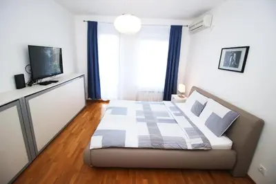 a bedroom with a bed and a television in a room at Apartment Delta City Tata New Belgrade in Belgrade