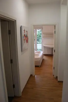 a hallway with a room with a bed and a window at Vanja’s place in Dušanovac (historical)