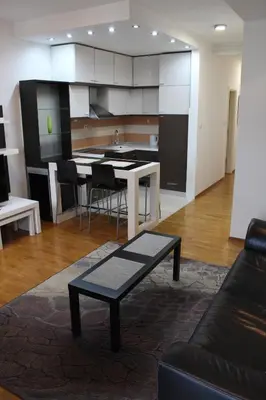 a living room with a table and a kitchen at Vanja’s place in Dušanovac (historical)