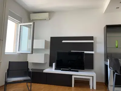 a living room with a tv and a white table at Vanja’s place in Dušanovac (historical)