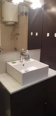 a bathroom with a white sink and a mirror at Vanja’s place in Dušanovac (historical)
