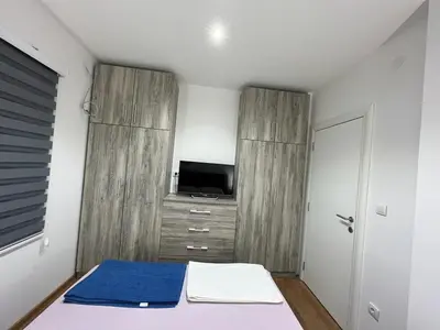 a small bedroom with a bed and a tv at Bamsae Belgrade in Vračar (historical)