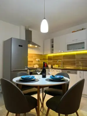 a kitchen with a table with chairs and a bottle of wine at Bamsae Belgrade in Vračar (historical)