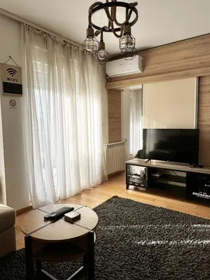 a living room with a flat screen tv and a table at Delete 5 - Zemunske Kapije in Belgrade