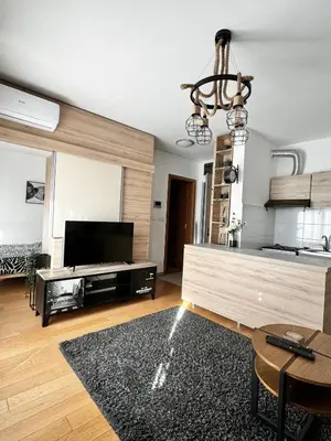 a living room with a television and a chandelier at Delete 5 - Zemunske Kapije in Belgrade
