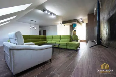 a living room with a green couch and a table at DeLux Center Apartments Inđija in Inđija