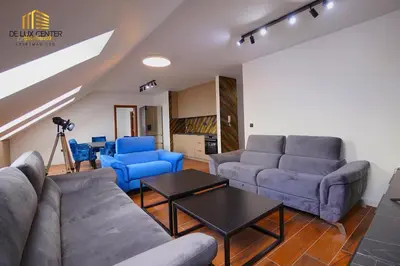 a living room with a couch and blue chairs at DeLux Center Apartments Inđija in Inđija