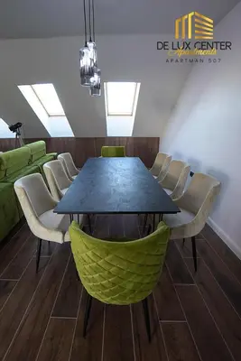 a dining room with a black table and chairs at DeLux Center Apartments Inđija in Inđija