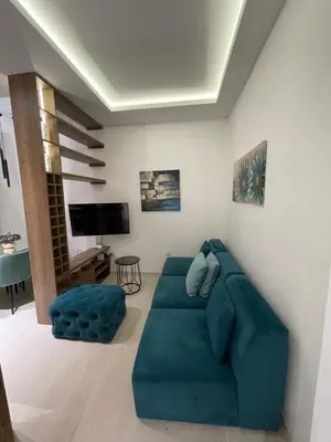 a living room with a blue couch and a tv at Belgrade Nest D&A in Belgrade