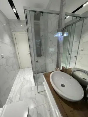 a white bathroom with a sink and a shower at Belgrade Nest D&A in Belgrade