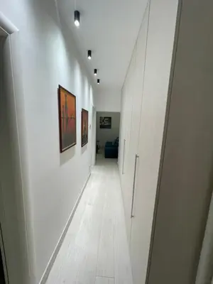 a corridor of a hallway with white walls and a wooden floor at Belgrade Nest D&A in Belgrade