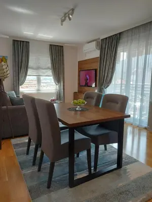 a dining room table and chairs in a living room at Apartman AuRa in Arandjelovac
