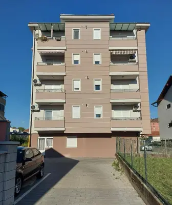 a tall building with a car parked in front of it at Apartman AuRa in Arandjelovac