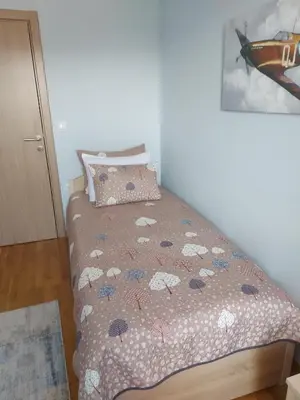 a bedroom with a bed with a comforter with umbrellas at Apartman AuRa in Arandjelovac