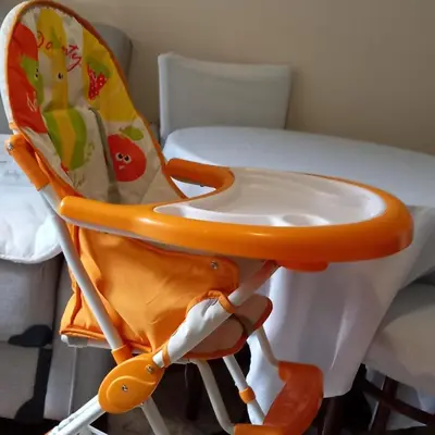 an orange and white high chair next to a table at Rivijera in Belgrade