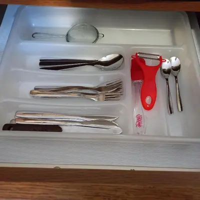 a white drawer filled with utensils and a red scissors at Rivijera in Belgrade