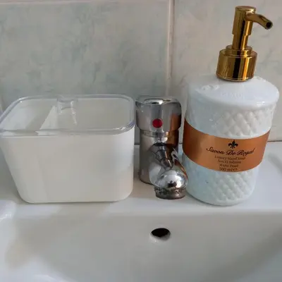a bathroom sink with a soap dispenser and a container at Rivijera in Belgrade