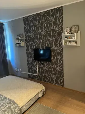 a bedroom with a bed and a tv on a wall at Grey in Belgrade