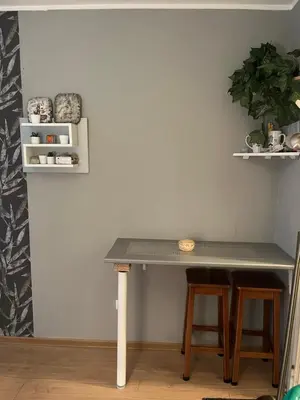 a table and two stools in a room at Grey in Belgrade