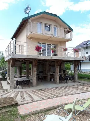 a house with a large deck with tables and chairs at River Casa in Ledine