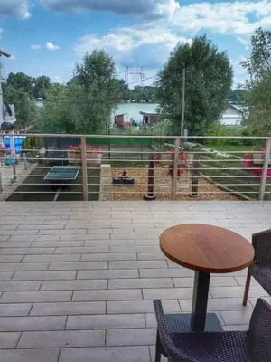 a patio with a table and chairs and a view of the water at River Casa in Ledine