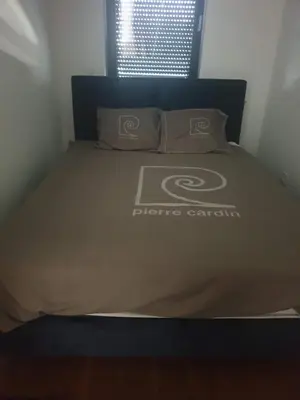 a bed in a room with a bedspread on it at Minel cosy apartment in Belgrade