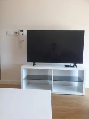 a white entertainment center with a flat screen tv on it at Minel cosy apartment in Belgrade