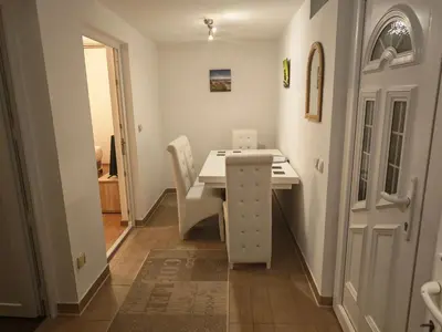 a white table and chairs in a room with a door at Apartman Anastasija in Surčin