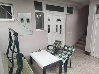 a living room with two chairs and a white table at Apartman Anastasija in Surčin