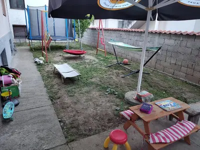 a patio with an umbrella and a table and chairs at Apartman Anastasija in Surčin