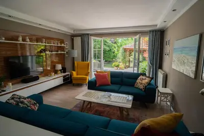 a living room with a blue couch and a tv at Family / Coworking Retreat Belgrade in Belgrade