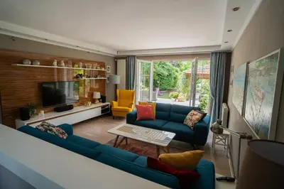a living room with blue couches and a tv at Family / Coworking Retreat Belgrade in Belgrade