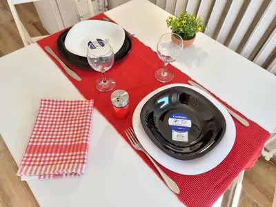a table with a black plate and two wine glasses at Sunset in Belgrade