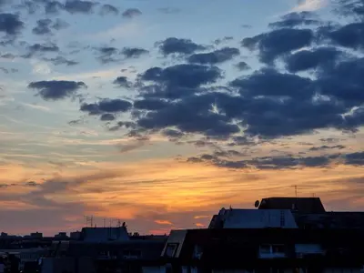 a cloudy sky at sunset with buildings at Sunset in Belgrade