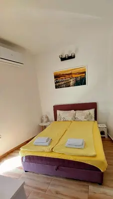 a bedroom with a bed with a yellow blanket on it at Sunset in Belgrade