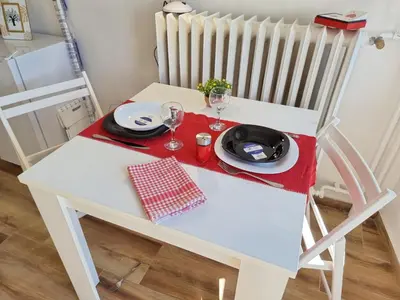 a white chair with a table with a plate and wine glasses at Sunset in Belgrade