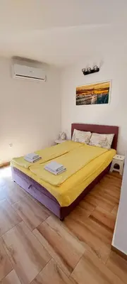 a bedroom with a large yellow bed in a room at Sunset in Belgrade