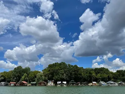 a group of houses on the water under a cloudy sky at Loup 1981 in Bežanija
