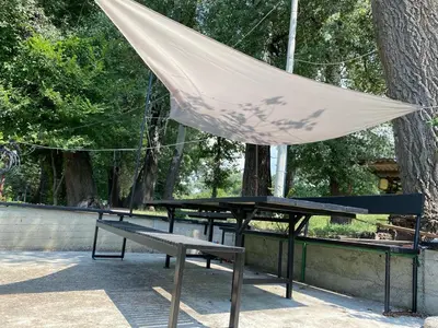 a picnic table with a tent over it in a park at Loup 1981 in Bežanija