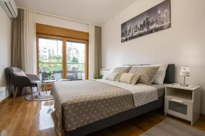 a bedroom with a large bed and a window at Martha apartments in Belgrade