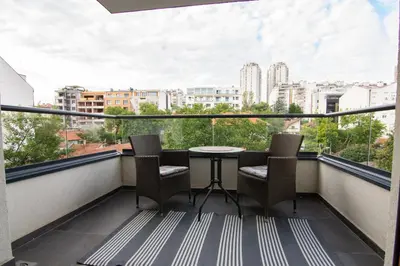 a balcony with a table and chairs and a city at Martha apartments in Belgrade