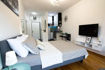 a bedroom with a bed and a flat screen tv at Martha apartments in Belgrade