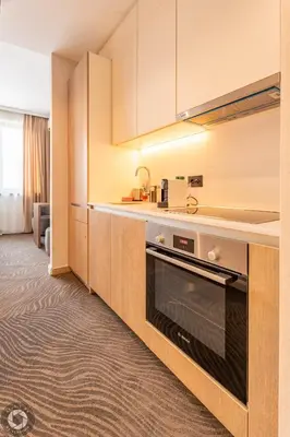 a kitchen with white cabinets and a stove at Belgrade Waterfront Luxury Studio in Belgrade