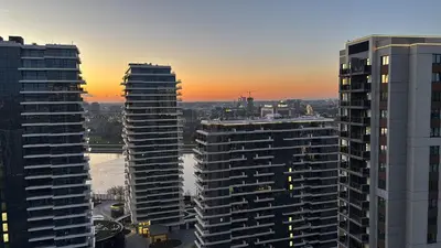 two tall buildings in a city at sunset at Belgrade Waterfront Luxury Studio in Belgrade